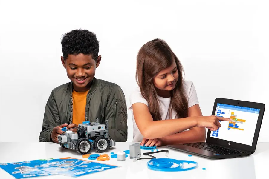 兩個孩子一起用筆電操作 VEX IQ 機器人