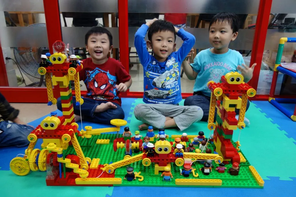 孩子們在教室地墊上展示自己拼好的樂高作品