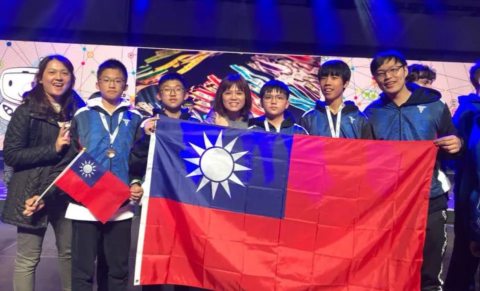 玩樂高手選手與老師拿著國旗在賽場合照
